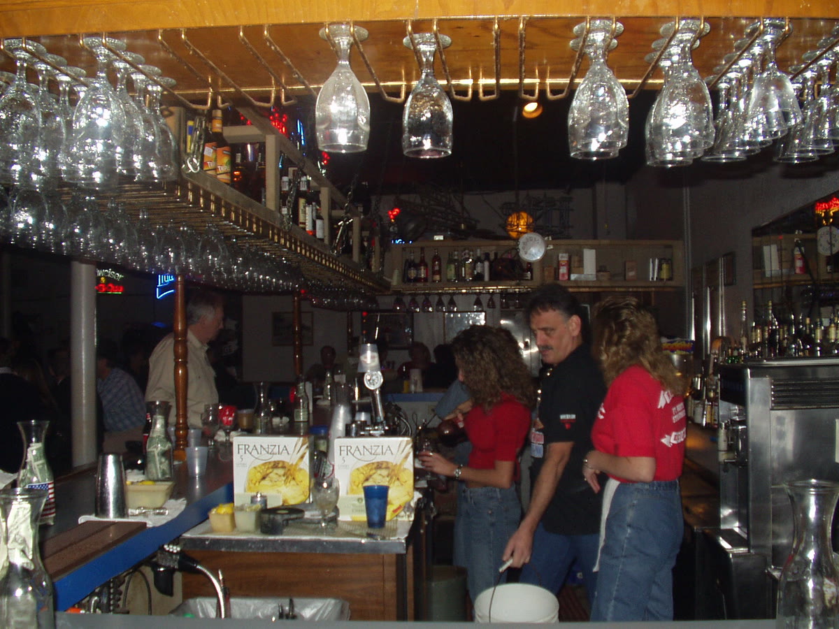The Rodeo Exchange bar in 2002 with hanging stemware and staff in red shirts