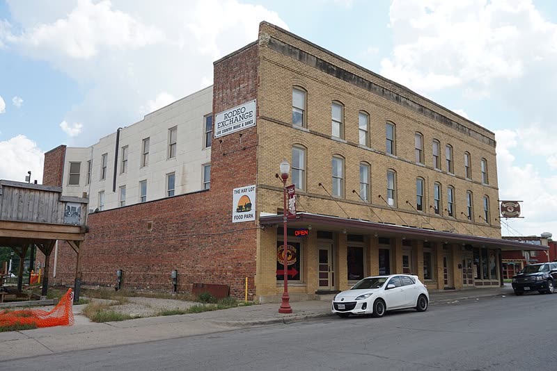 The Cody Building at 221 W Exchange Avenue, three storeys of brick with the painted Rodeo Exchange wall sign