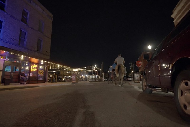 Exchange Avenue at night, lit storefronts running down the street